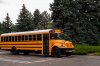 yellow-school-bus-parked-street-big-near-trees-194957312-947656066.jpg